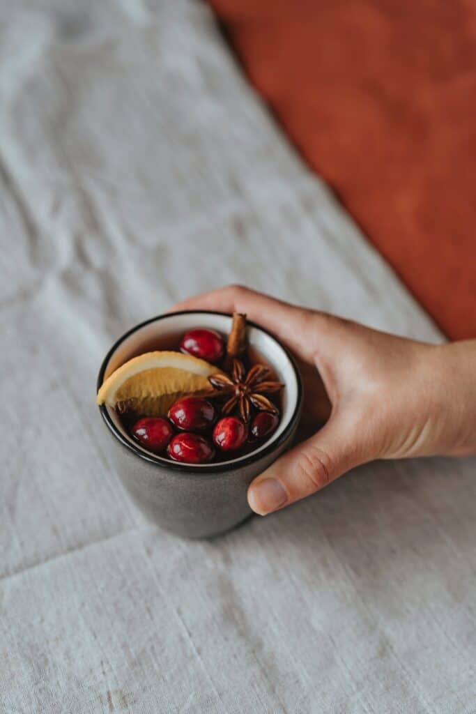 Ein Aromatischer gewürzter Glühwein der von einer Frau auf einem Tisch serviert wird